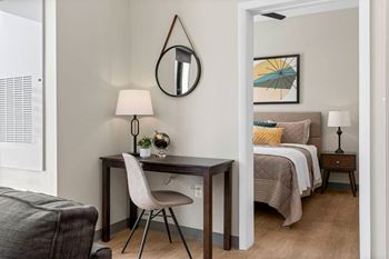 a bedroom with a bed and a desk in a room